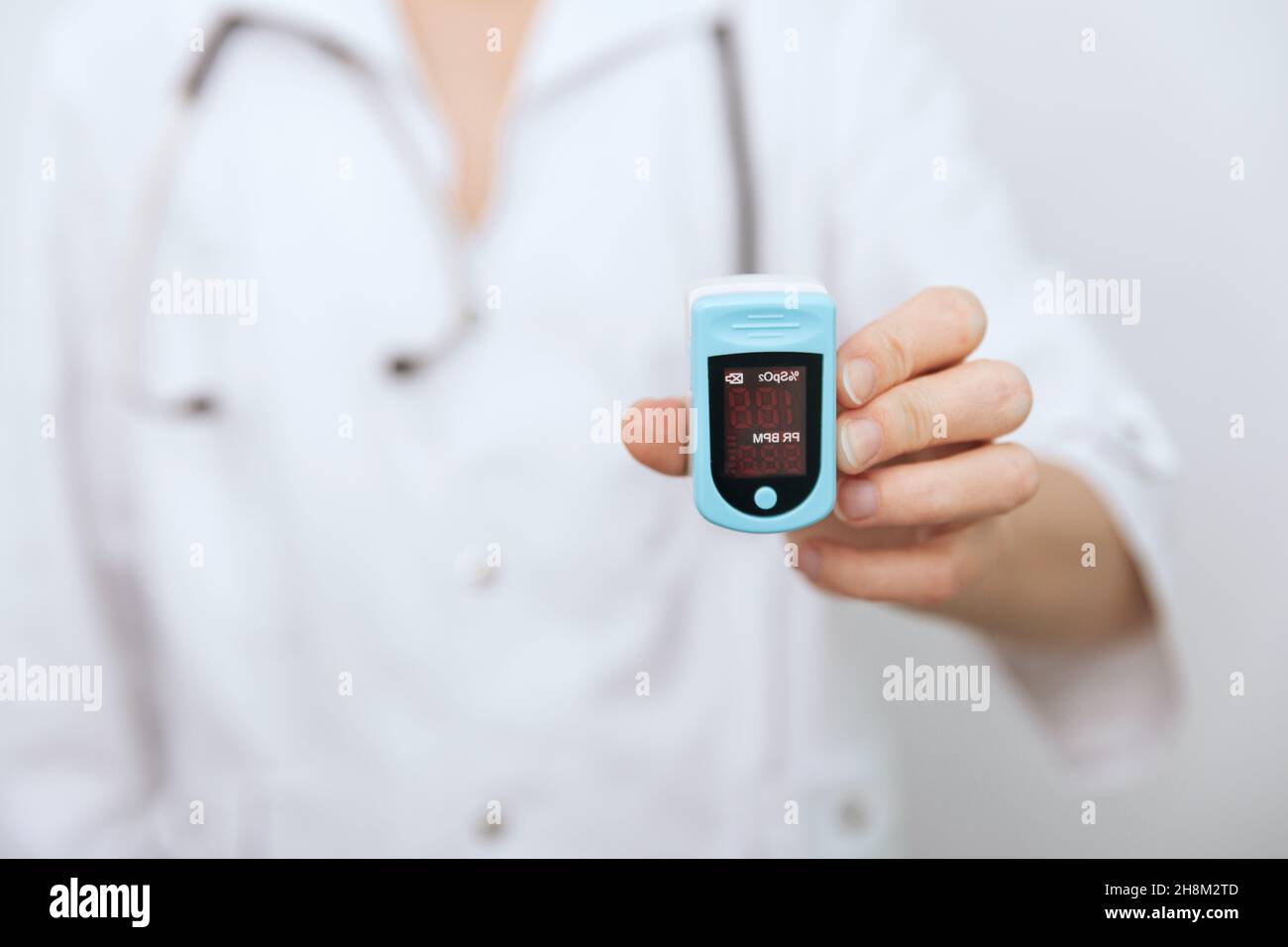 Pulsoximeter mit der Hand des Arztes auf Weiß isoliert. Das Konzept eines tragbaren digitalen Geräts zur Messung der Sauerstoffsättigung von Personen. Messung von Sauerstoff Stockfoto