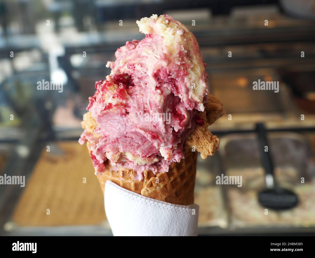Eis in einer Waffelbecher auf unscharfem Hintergrund. Stockfoto