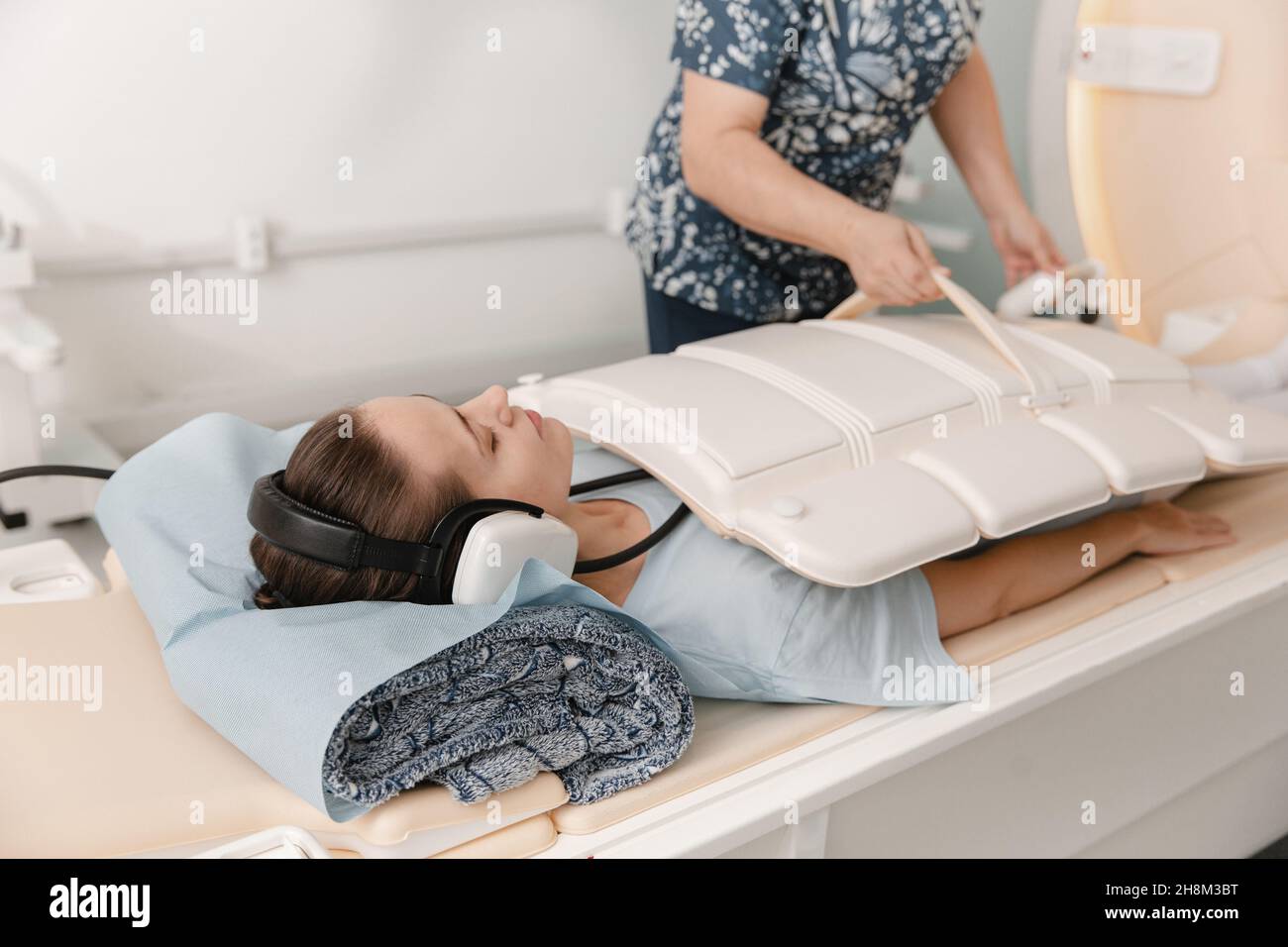 Arzt oder Krankenschwester und Patient mit Tomographie-CT oder MRI-Scan im Krankenhaus. Innenansicht der Radiographie-Abteilung. Technologisch fortschrittliche Ausrüstung in Stockfoto