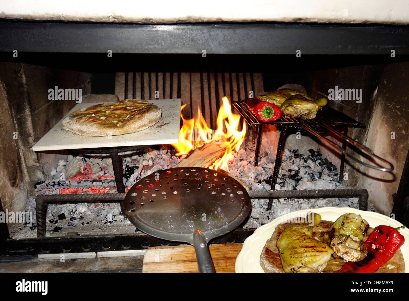 Rustikales Essen im Kamin im Innenbereich zubereitet Stockfoto
