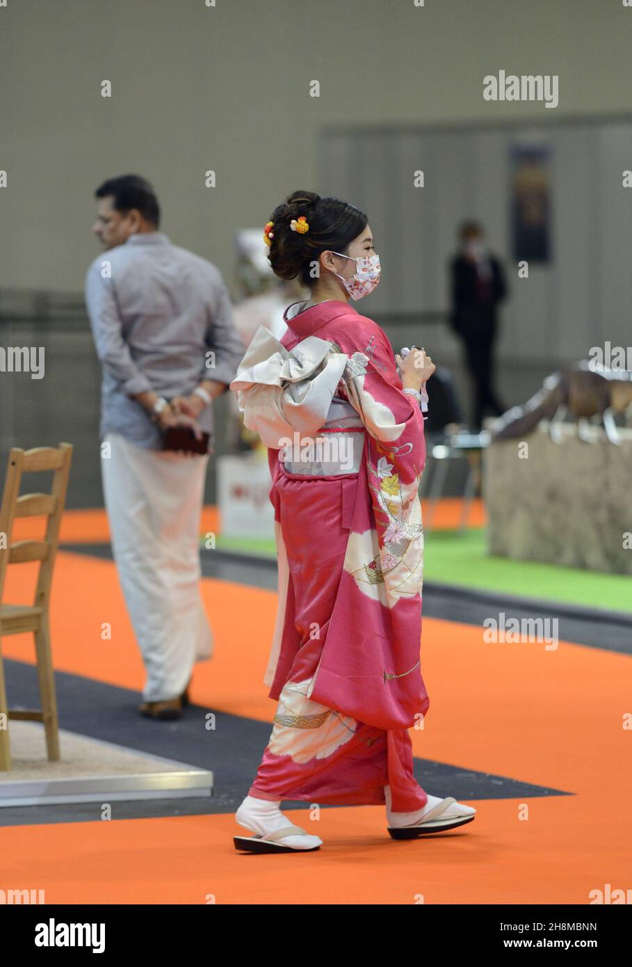 World Travel Market (WTM) im Excel London, November 2021. Japanische Frau mit einem Kimono und einer COVID-Gesichtsmaske Stockfoto