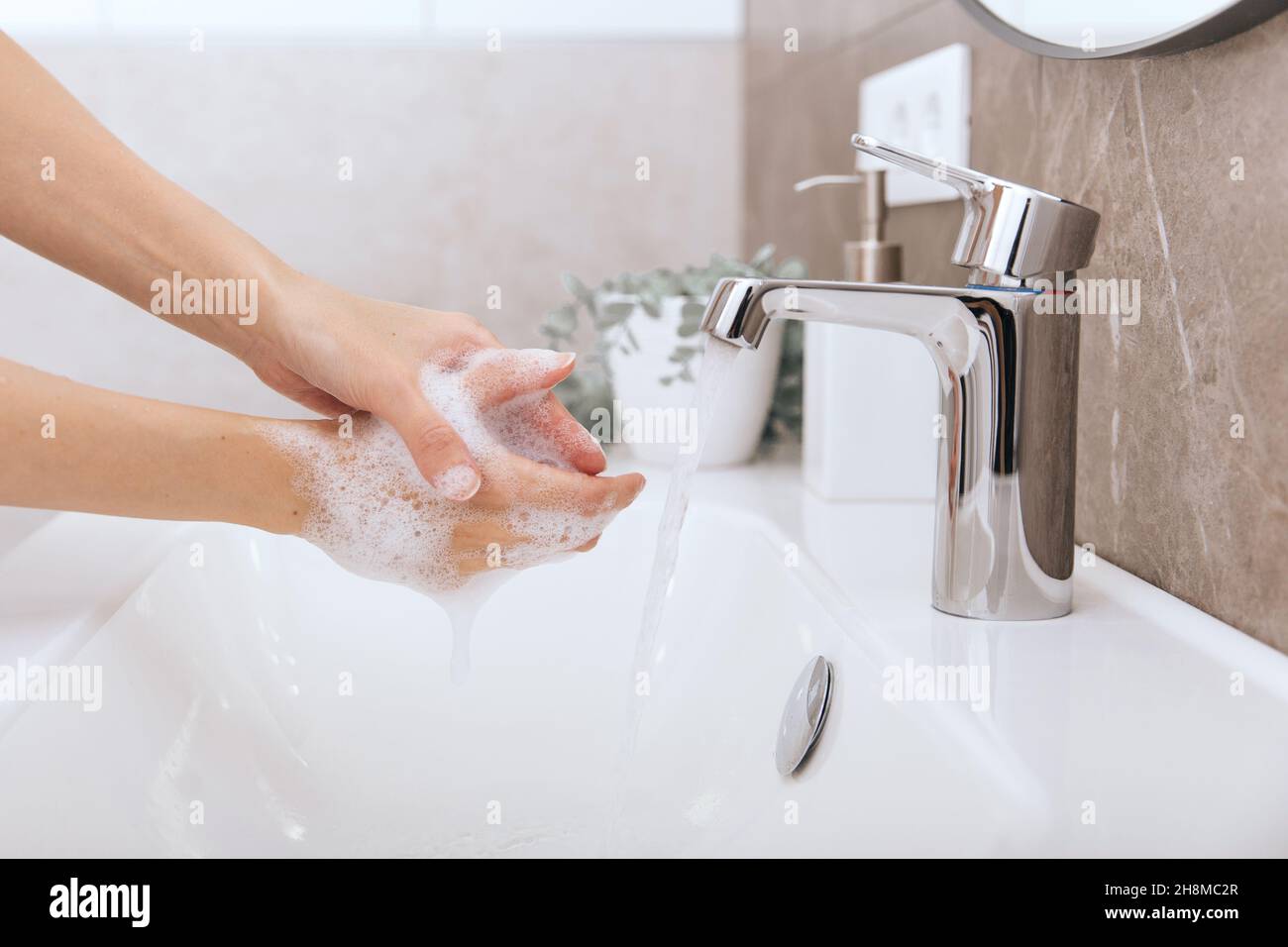 Händewaschen unter dem fliessenden Wasserhahn. Hygienekonzept Handdetail. Waschen der Hände reiben mit Seife für Corona-Virus Prävention, Hygiene zu stoppen Stockfoto