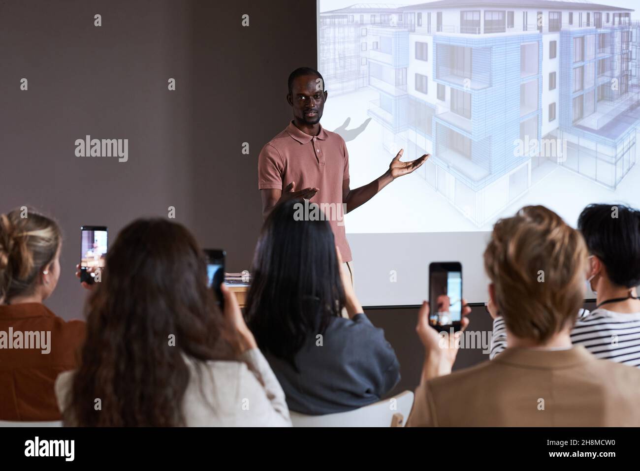 Afrikanischer junger Geschäftsmann präsentiert neues Projekt des neuen Gebäudes für Menschen auf der Konferenz Stockfoto