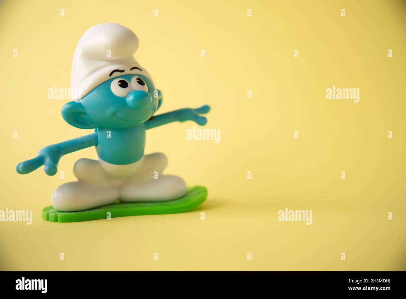 Abbildung von Schlümpfen Surfen auf gelbem Hintergrund Stockfoto