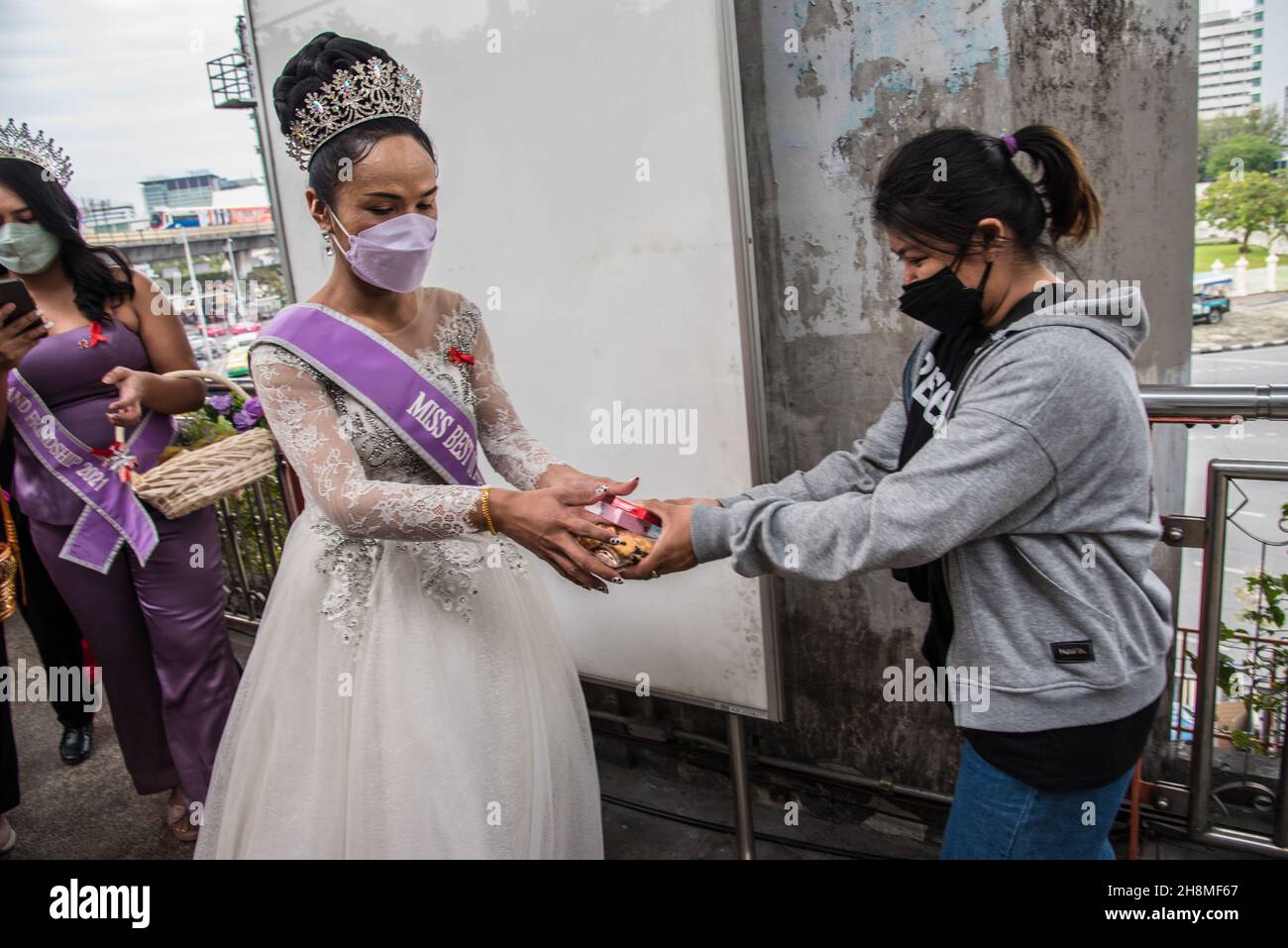 Eine Frau erhält Kondome von Panurat Noibunjong 'Miss LGBT Thailand Friendship 2021' während der Kampagnen zum Welt-Aids-Tag 2021. Zum Welt-Aids-Tag 2021 wurden im Bezirk Ratchathewi, Bangkok, am Siegesdenkmal anlässlich des Welt-Aids-Tages 2021 Kampagnen durchgeführt. Das Thema des Welt-Aids-Tages 2021 der Weltgesundheitsorganisation (WHO) lautet „Beseitigung von Ungleichheiten. End AIDS“. „mit einem besonderen Fokus darauf, die zurückgelassenen Menschen zu erreichen und die wachsenden Ungleichheiten beim Zugang zu wichtigen HIV-Dienstleistungen hervorzuheben. (Foto von Peerapon Boonyakiat/SOPA Images/Sipa USA) Stockfoto