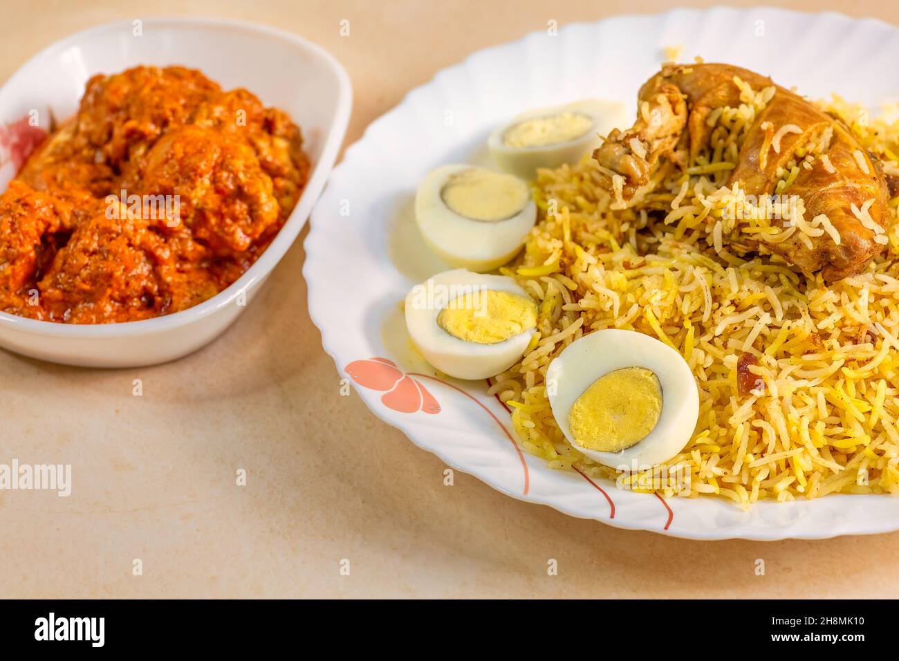 Würzige indische Biryani mit Hühnerkeule und in Scheiben geschnittenen Eiern in Nahaufnahme Stockfoto