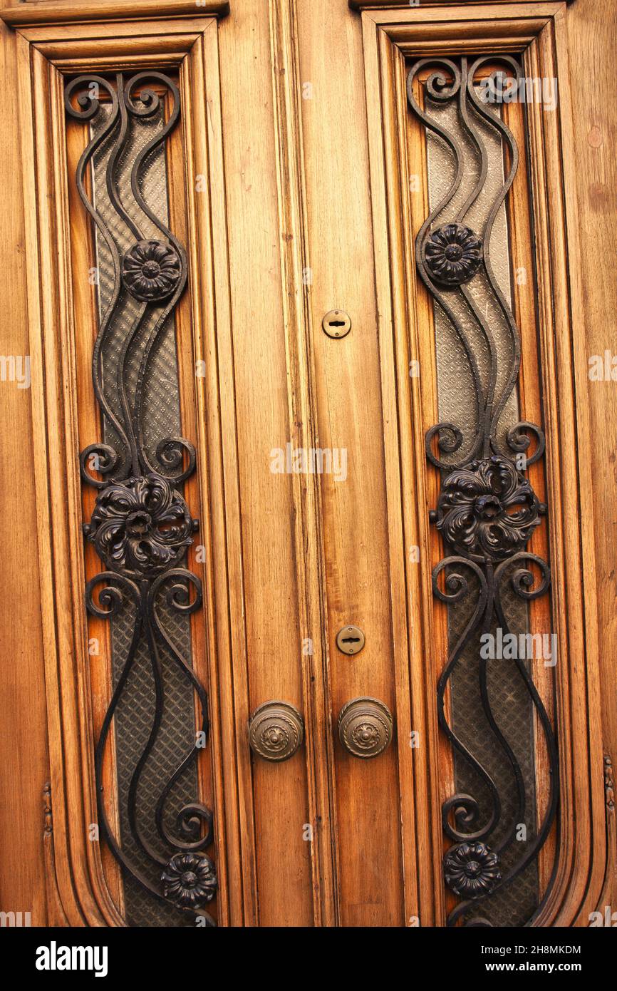 Vertikale Aufnahme einer alten Holztür mit zwei Seiten und dekorativen Eisenmustern Stockfoto