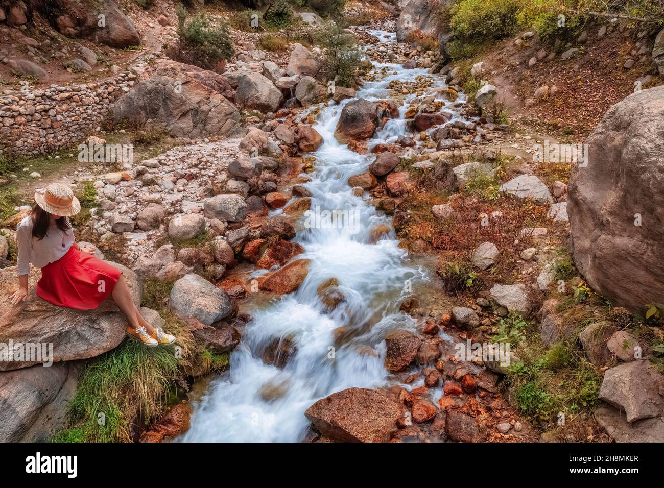 Weibliche Touristen Pose für Fotografie in der Nähe eines Bergwasserfalls in der Nähe von Sangla bei Himachal Pradesh Indien Stockfoto