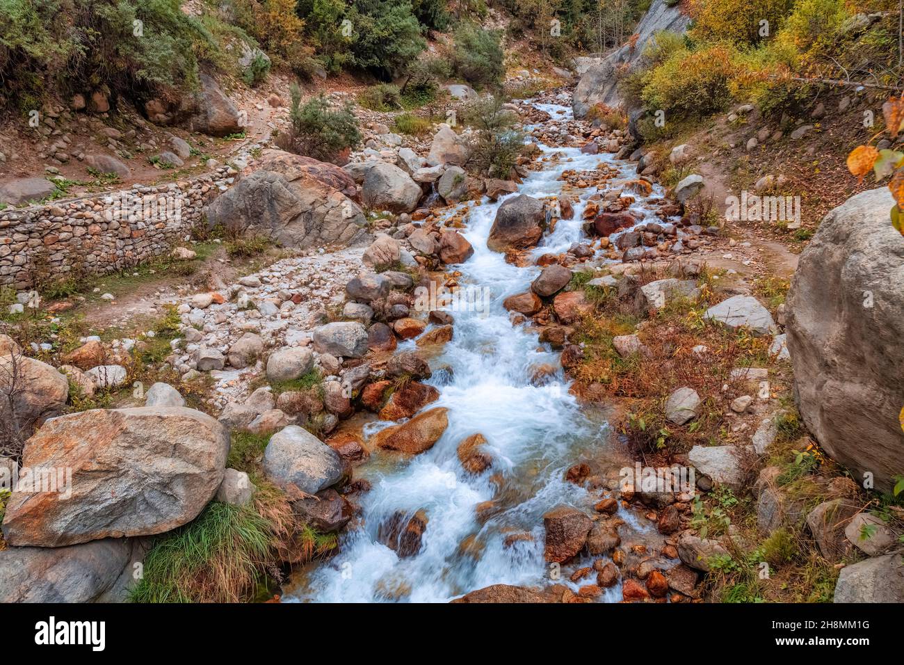 Bergwasserfall mit Felsen und Felsbrocken im Himalaya bei Sangla Himachal Pradesh, Indien Stockfoto