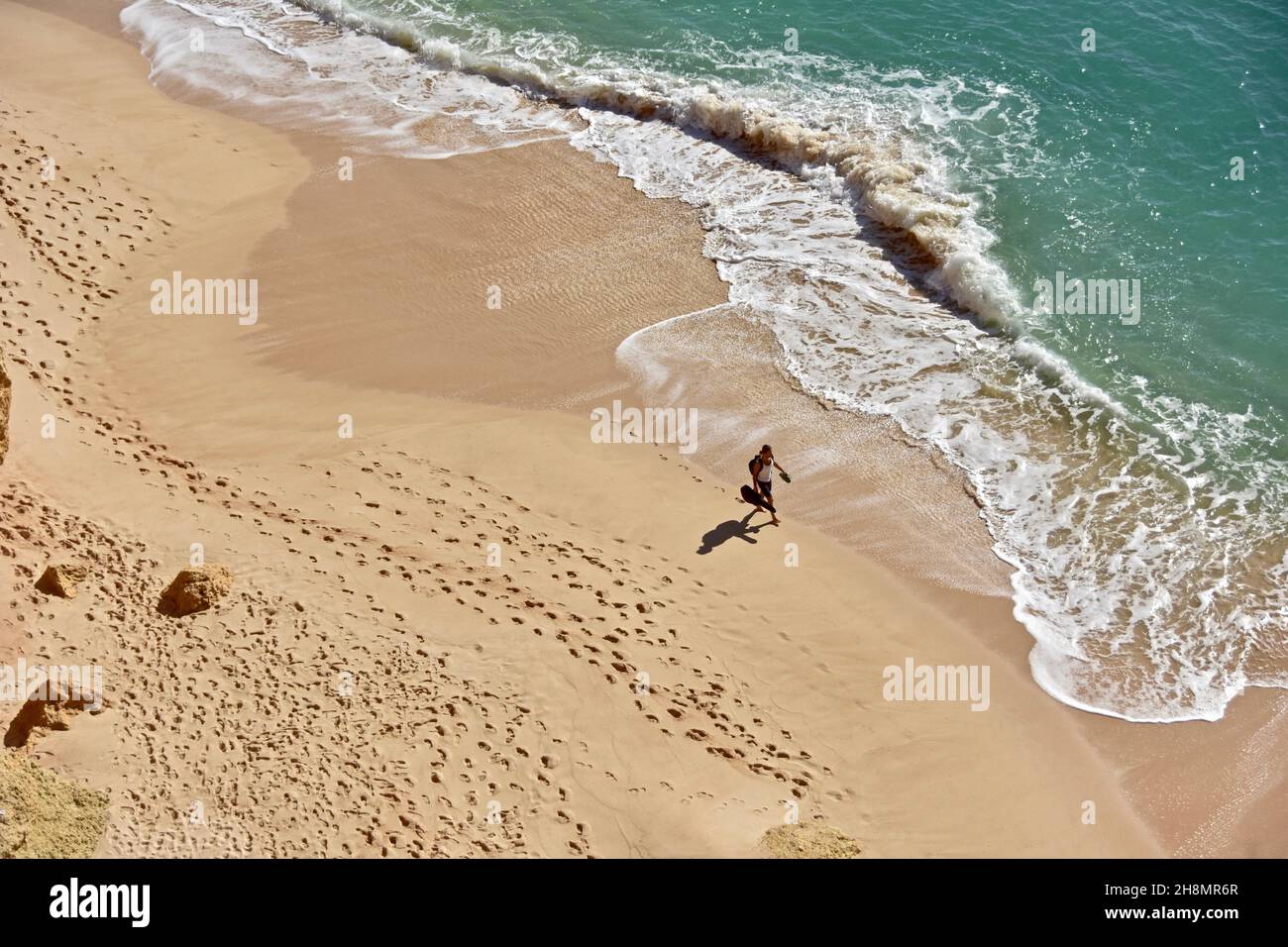 Mann mit Gitarre am Strand von oben, Urlaub, Freizeit, Reisefotografie, Urlaubsfoto, Mann, der mit Gitarre auf dem Meer läuft, Algallve, Portugal Stockfoto