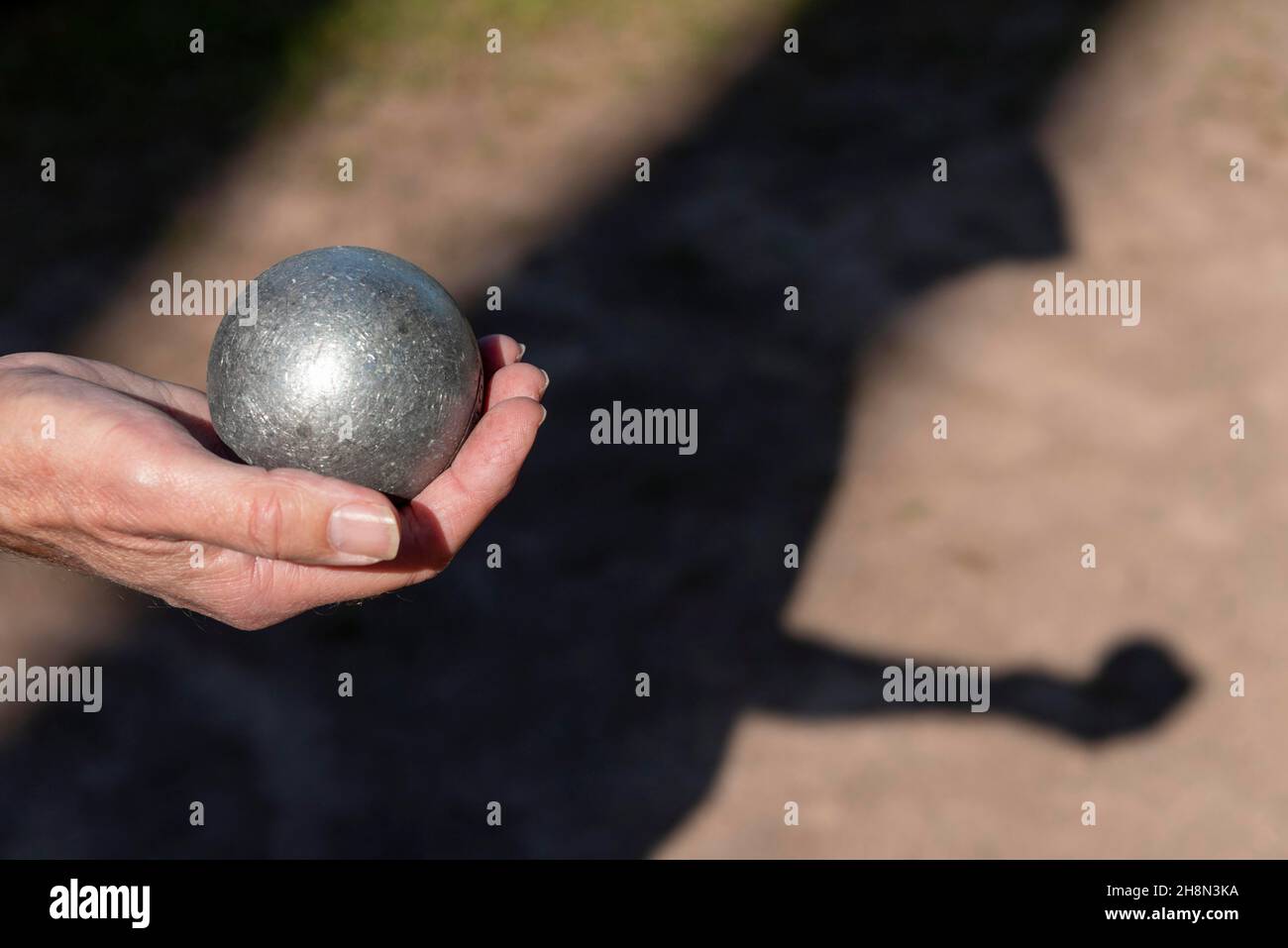 Männerhand mit Petanque-Ball, Boule Court, Deutschland Stockfoto
