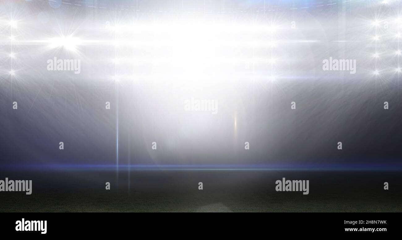 Beleuchteter american Football-Sportplatz mit leuchtenden hellen Lichtern in der Nacht Stockfoto