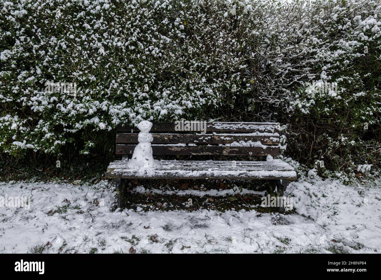Ein Mini-Schneemann auf einer Parkbank, Brungerley Park, Clitheroe, Ribble Valley, Lancashire, VEREINIGTES KÖNIGREICH. Stockfoto