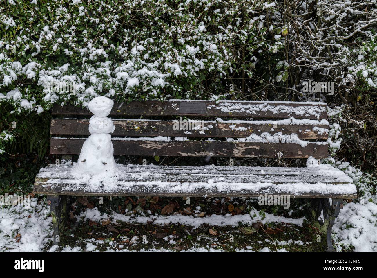 Ein Mini-Schneemann auf einer Parkbank, Brungerley Park, Clitheroe, Ribble Valley, Lancashire, VEREINIGTES KÖNIGREICH. Stockfoto