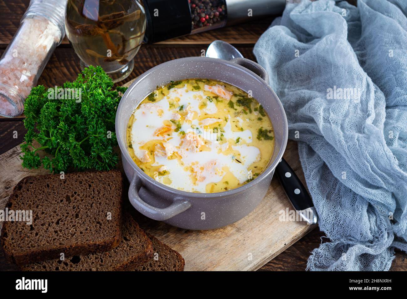 Cremige Lachssuppe mit Kartoffeln, Karotten, Lauch und Brot. Lohikeitto-Suppe, finnische Küche Stockfoto