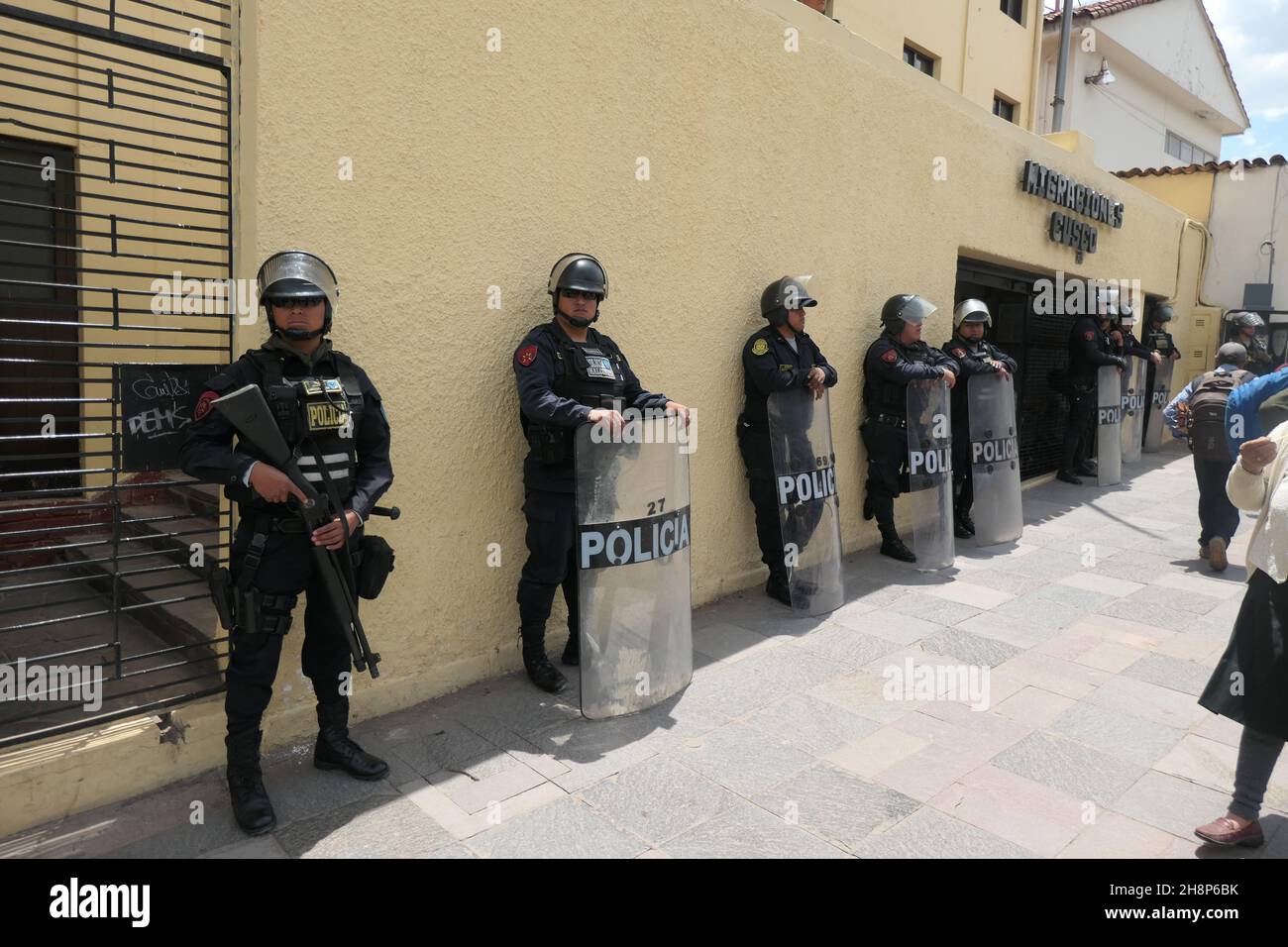 Peruanische Polizei mit Schilden auf der Straße bei Carnival Cusco Aufstand Aufstände Revolver Gewehre Schrotflinten bewaffnet wartende Terroristen Einfallshelm Stockfoto