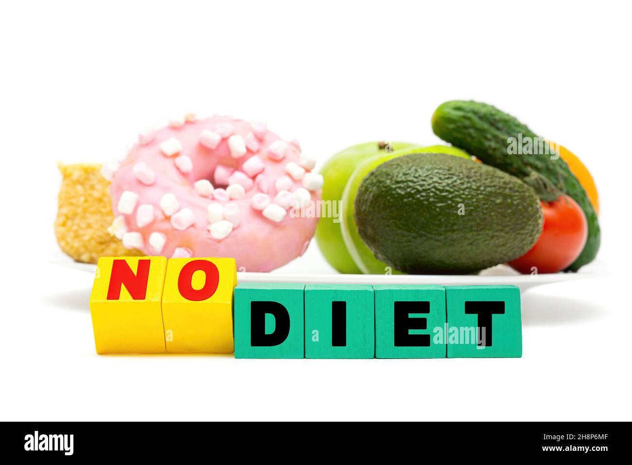 Essverhalten und Lebensmittelentscheidungskonzept. Text KEINE DIÄT aus Buchstabenblöcken vor einem weißen Teller mit Süßigkeiten, Obst und Gemüse. Stockfoto