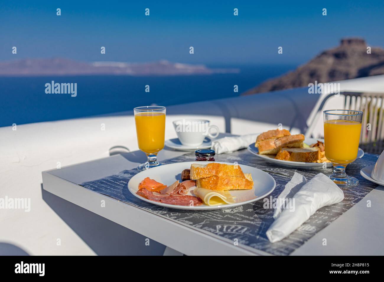 Frühstückstisch romantischer Blick unter dem idyllischen blauen Himmel Meer. Perfekter luxuriöser Frühstückstisch für zwei Personen im Freien. Toller Blick auf die Caldera von Oia Santorini Stockfoto
