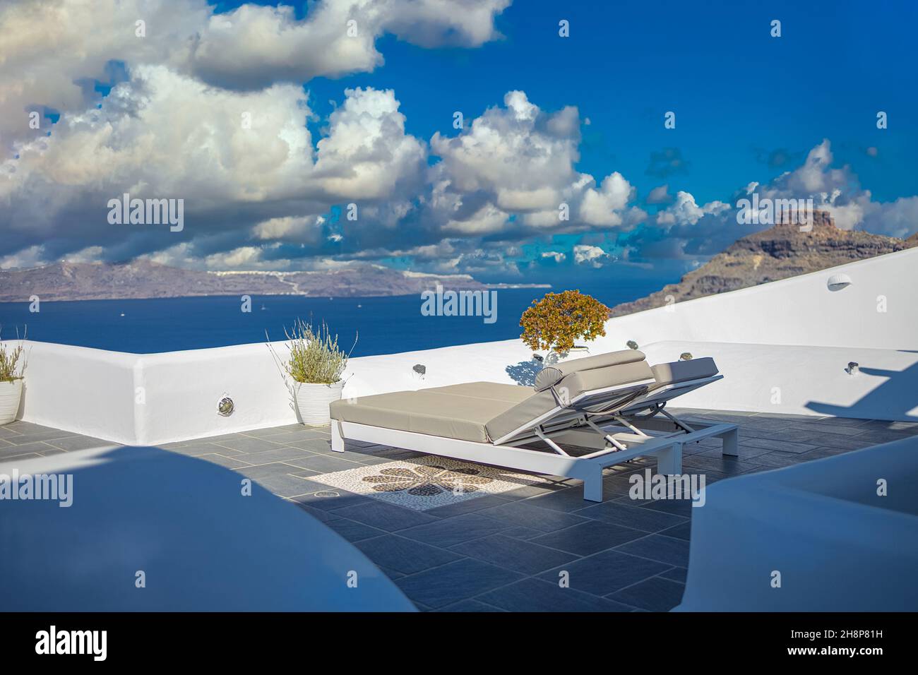 Santorini Insel, Oia Caldera Szene, zwei Sonnenliegen, Liegen, erstaunlich sonnigen Meerblick Horizont Erholung Ruhe entspannen szenisch. Inspirierendes Strandresort Stockfoto