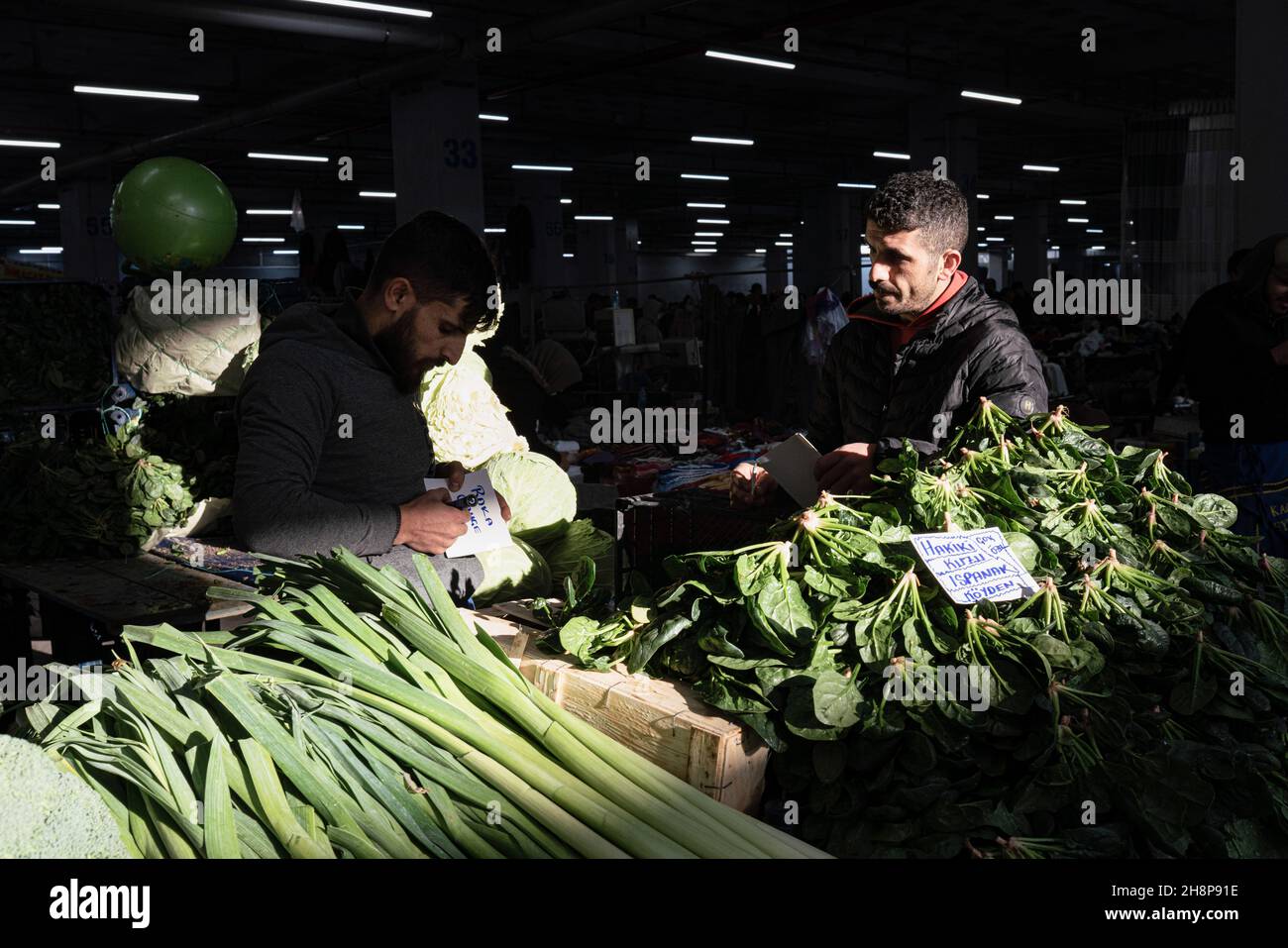 Istanbul, Türkei. 26th. November 2021. Zwei Händler schreiben auf einem lokalen Markt in Istanbul Schilder mit Gemüsepreisen. Die Türkei durchläuft eine sehr tiefe Wirtschaftskrise. Im Dezember 1st traf die türkische Lira ihren größten Hit seit zwei Jahrzehnten, nachdem Erdoganís beschlossen hatte, die Zinssenkungen zu vertiefen. Türkische Haushalte, insbesondere einkommensschwächere, müssen mit höheren Preisen für Waren kämpfen - einschließlich der Grundnahrungsmittel wie Lebensmittel und Energie. (Foto von Alba Cambeiro/SOPA Images/Sipa USA) Quelle: SIPA USA/Alamy Live News Stockfoto