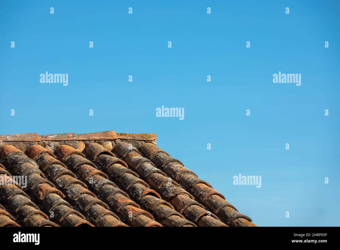 Altes spanisches Fliesendach mit blauem Himmel Stockfoto
