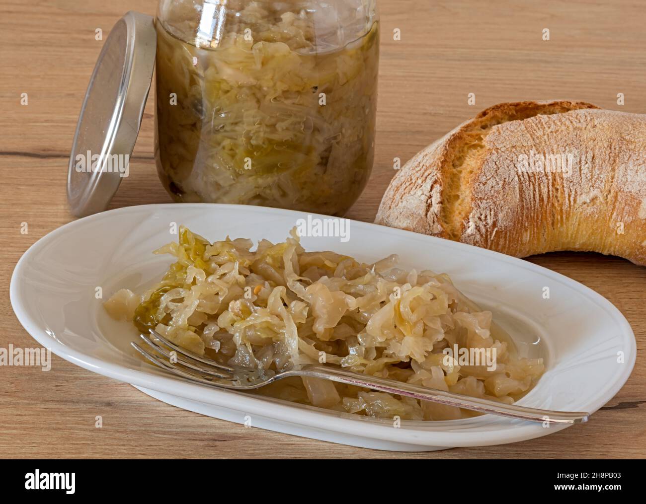 piatto con crauti vaso con crauti e pane sul tavolo della cucina Stockfoto