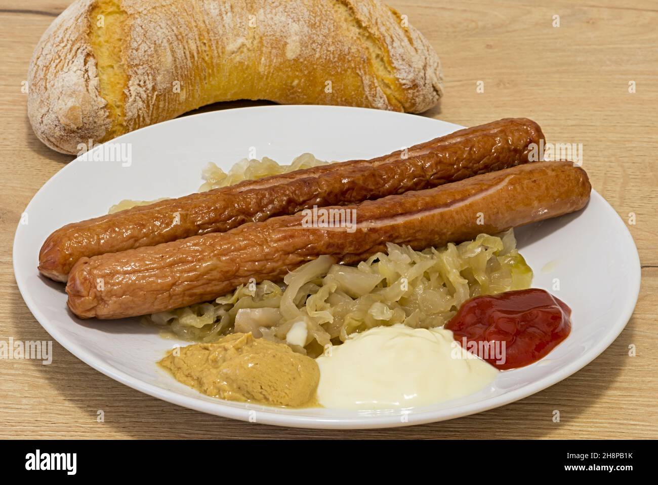 Wurstel cotti con crauti nel piatto in Primo Piano Stockfoto