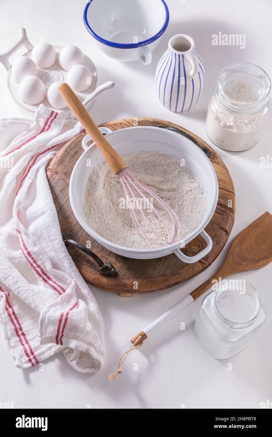 Mehl und Ei mit Backzutaten und Küchenutensilien Stockfoto