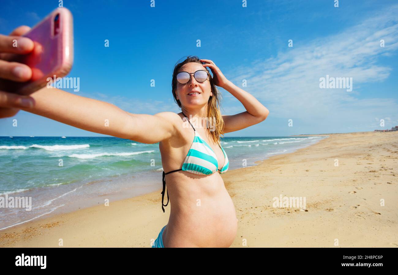 Eine Schwangerin fotografiert sie am Strand Stockfoto