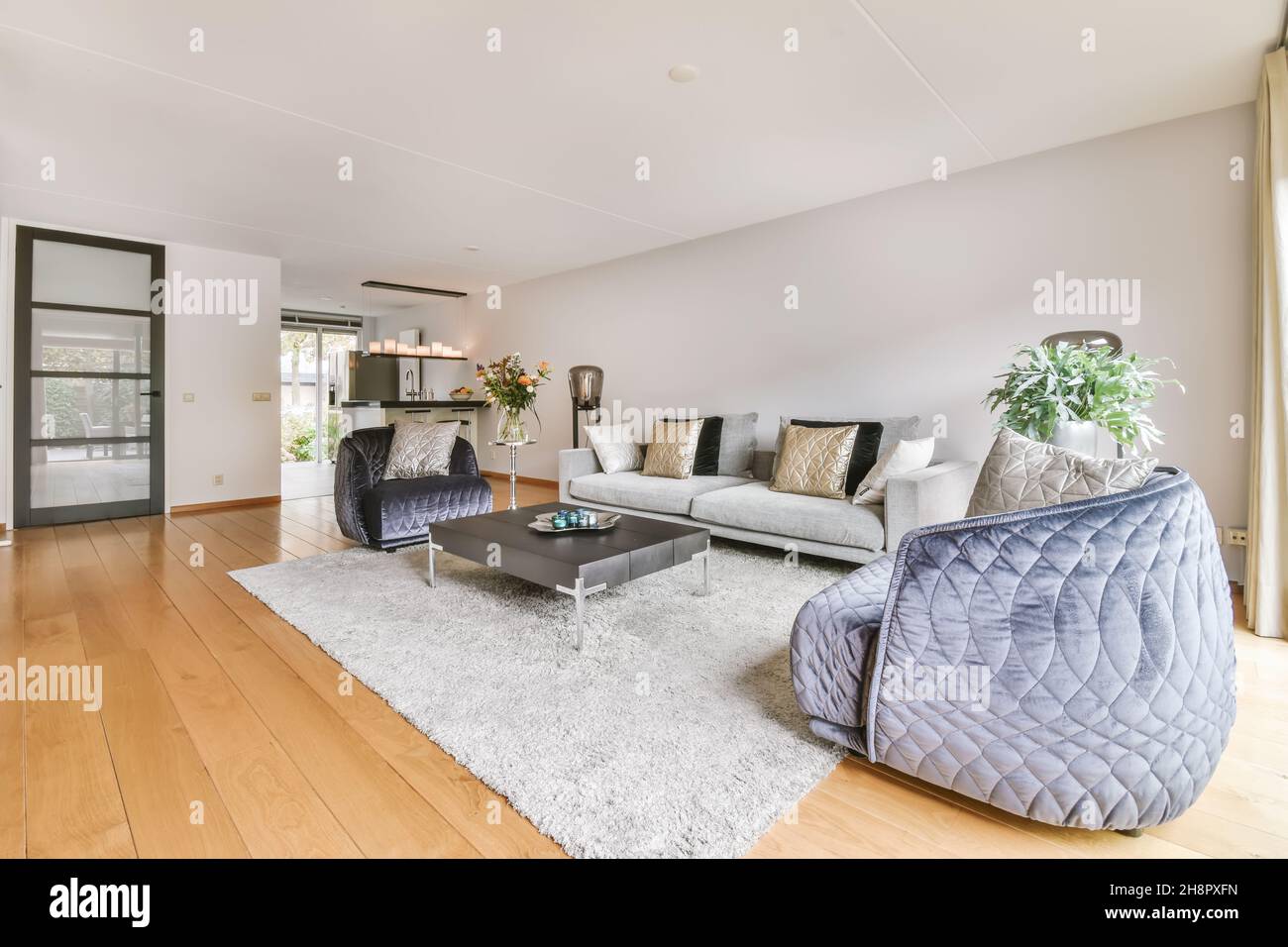 Einfache, teure Innenausstattung des Wohnzimmers mit Teppich und Beige Sofa Stockfoto