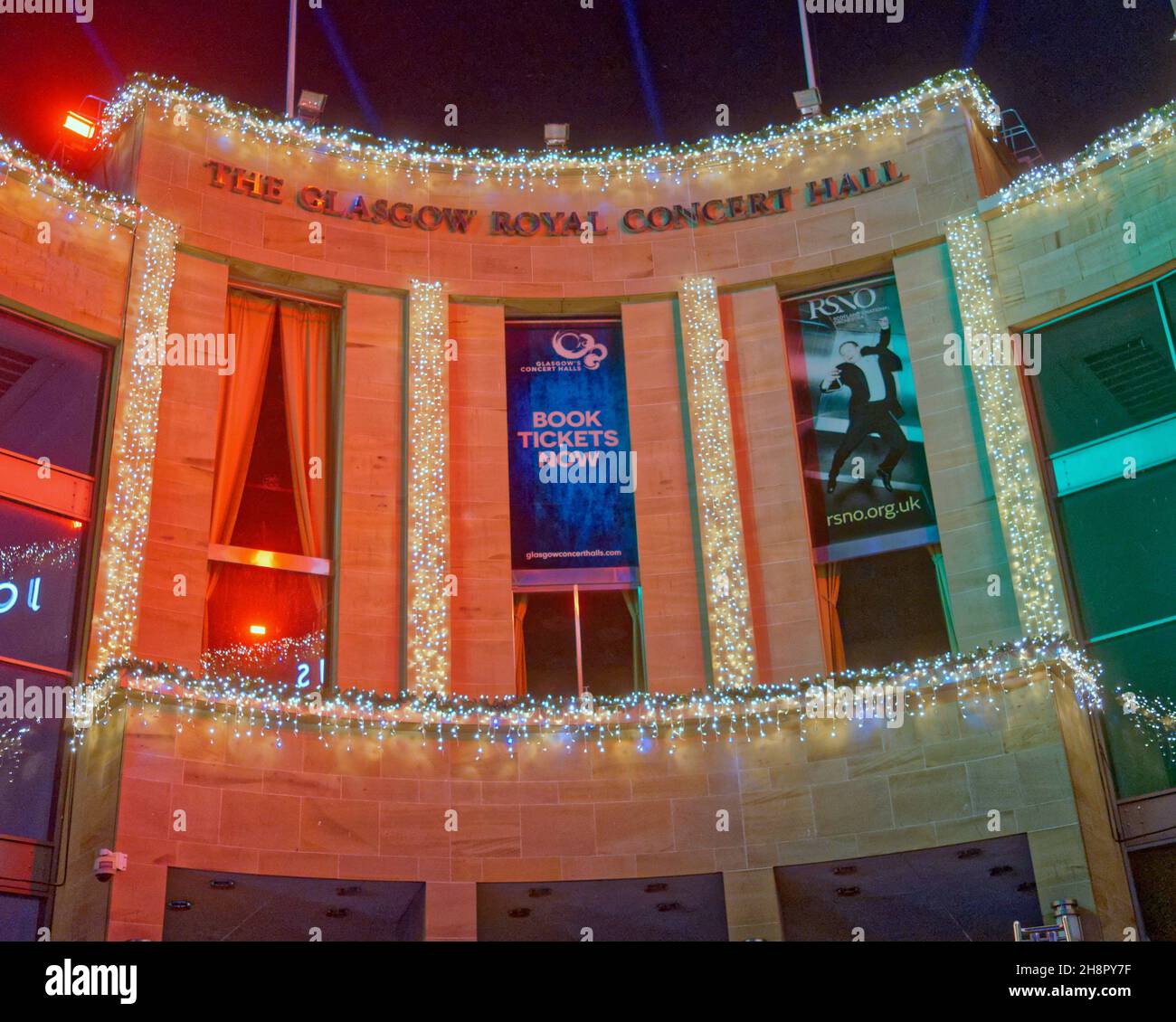 Glasgow, Schottland, Vereinigtes Königreich 1st. Dezember 2021. Glasgow beleuchtet die Stadtkammern zu weihnachten und beginnt den Lichtweg, der die im Stadtstil gehaltene Meile der buchanan Street umfasst, die mit der königlichen Konzerthalle an der Spitze endet. Die Stufen der königlichen Konzerthalle und die donald-Dewar-Statue mit einer Projektion an den Wänden von john lewis. Credit Gerard Ferry/Alamy Live News Stockfoto