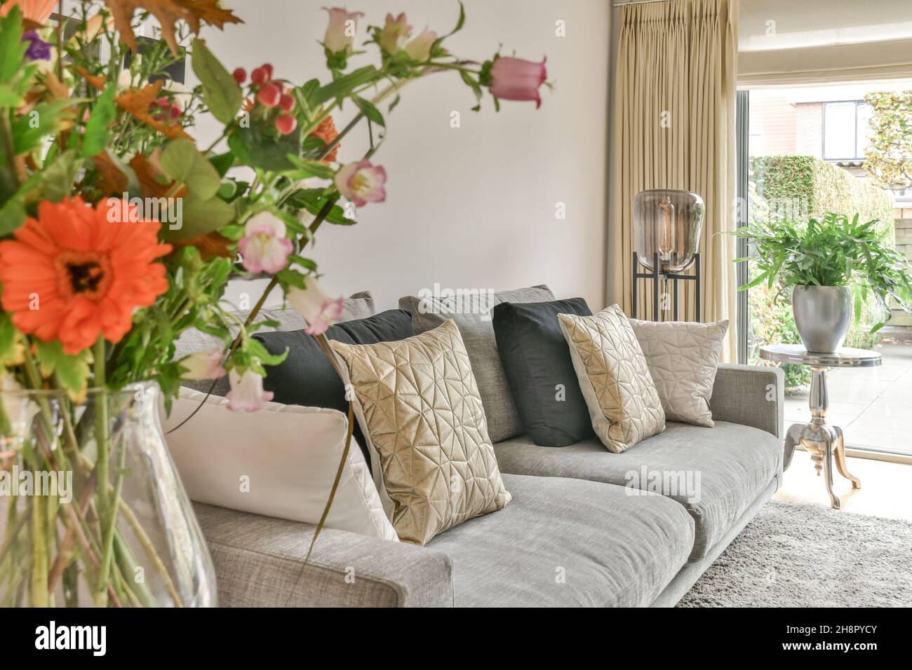 Einfache, teure Innenausstattung des Wohnzimmers mit Teppich und Beige Sofa Stockfoto