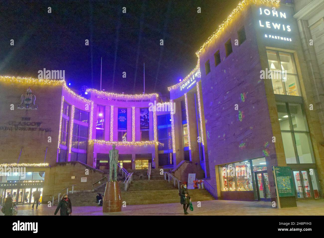 Glasgow, Schottland, Vereinigtes Königreich 1st. Dezember 2021. Glasgow beleuchtet die Stadtkammern zu weihnachten und beginnt den Lichtweg, der die im Stadtstil gehaltene Meile der buchanan Street umfasst, die mit der königlichen Konzerthalle an der Spitze endet. Die Stufen der königlichen Konzerthalle und die donald-Dewar-Statue mit einer Projektion an den Wänden von john lewis. Credit Gerard Ferry/Alamy Live News Stockfoto