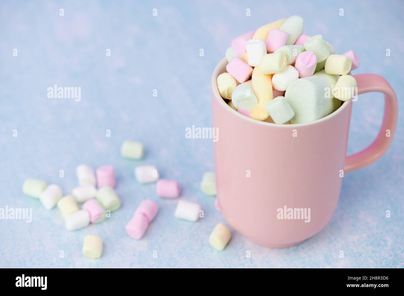 Rosa Tasse mit bunten Marschmallchen Stockfoto
