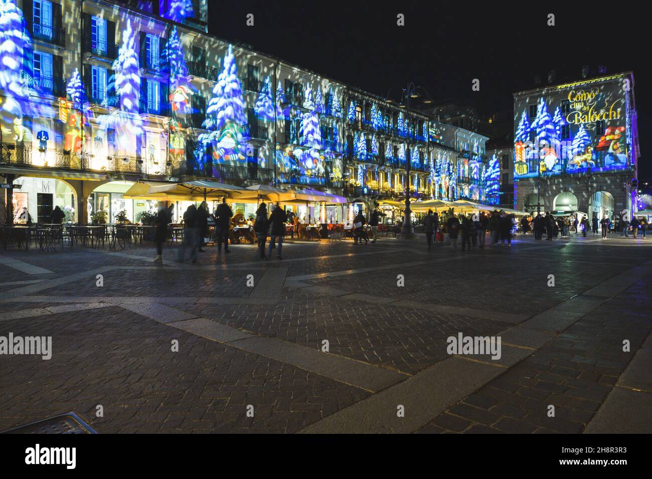 COMO, ITALIEN, DEZEMBER 2021: Festliche Weihnachtsdekorationen leuchten an den Fassaden der Gebäude auf der Piazza Duomo (Domplatz) im Zentrum der Altstadt von Como Stockfoto