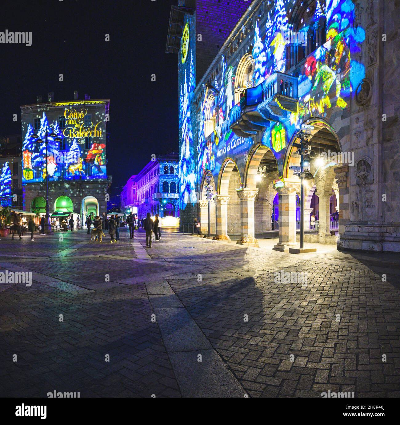 COMO, ITALIEN, DEZEMBER 2021: Festliche Weihnachtsdekorationen leuchten an den Fassaden der Gebäude auf der Piazza Duomo (Domplatz) im Zentrum der Altstadt von Como Stockfoto