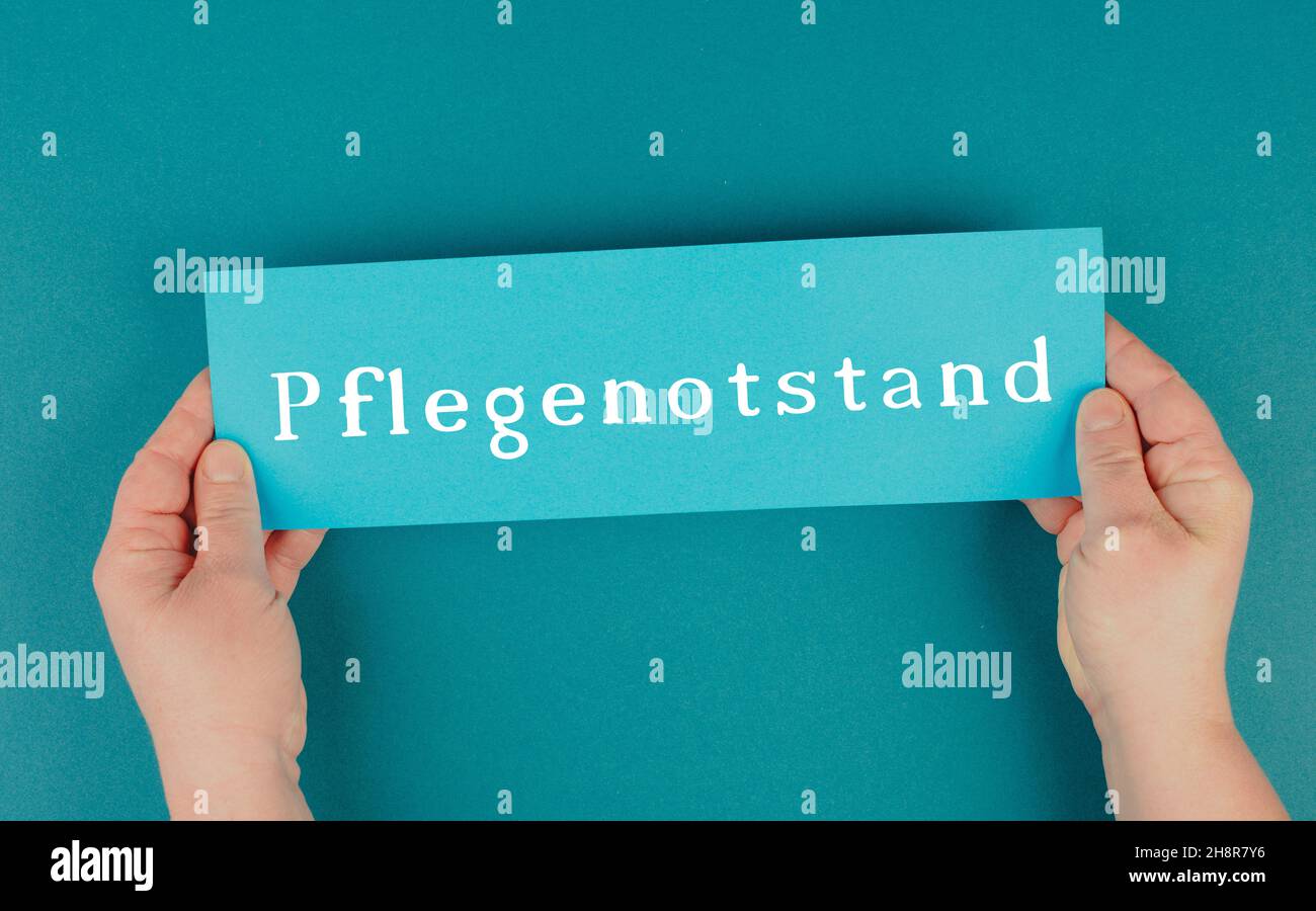 Das Wort Pflegehotstand steht in deutscher Sprache auf einem blau gefärbten Papier Stockfoto