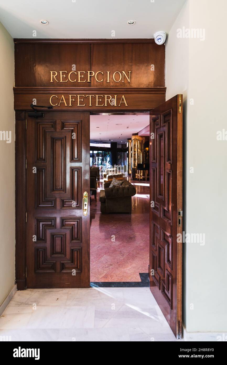 Öffnen Sie die Holztür zur Rezeption und Cafeteria des Hotels mit goldenen Schriftzügen Stockfoto