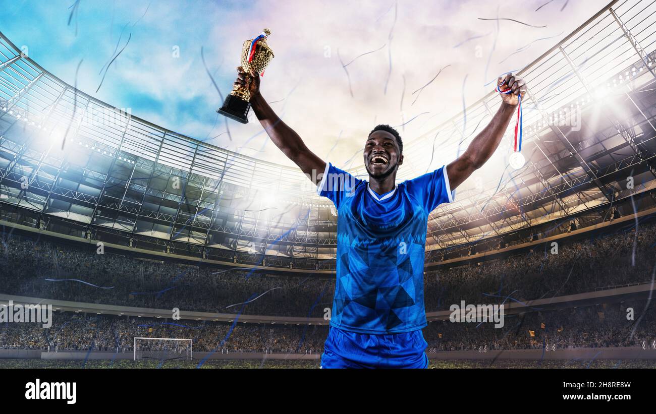 Fußballspieler in blauer Uniform freut sich über den Sieg einer Trophäe im Stadion Stockfoto