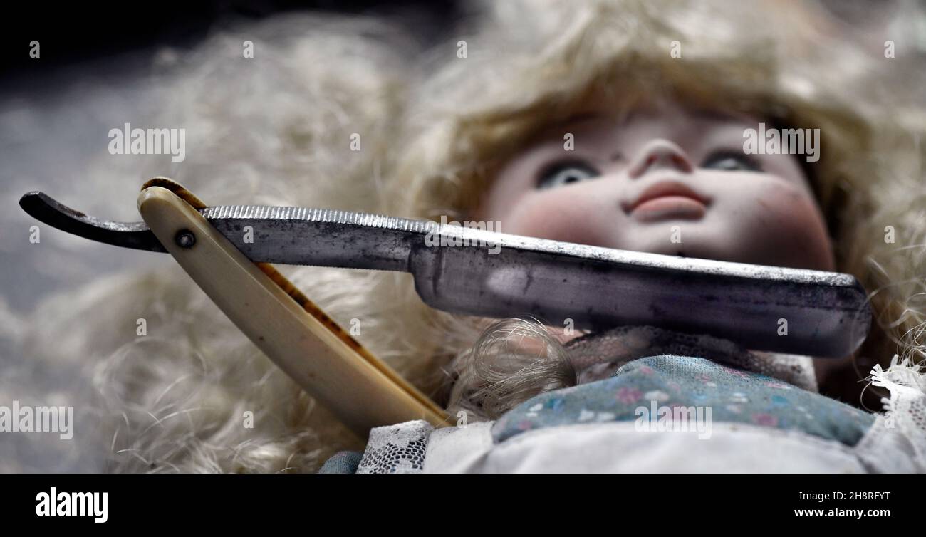childs Puppe mit Vintage Cut Razor an der Kehle Stockfoto