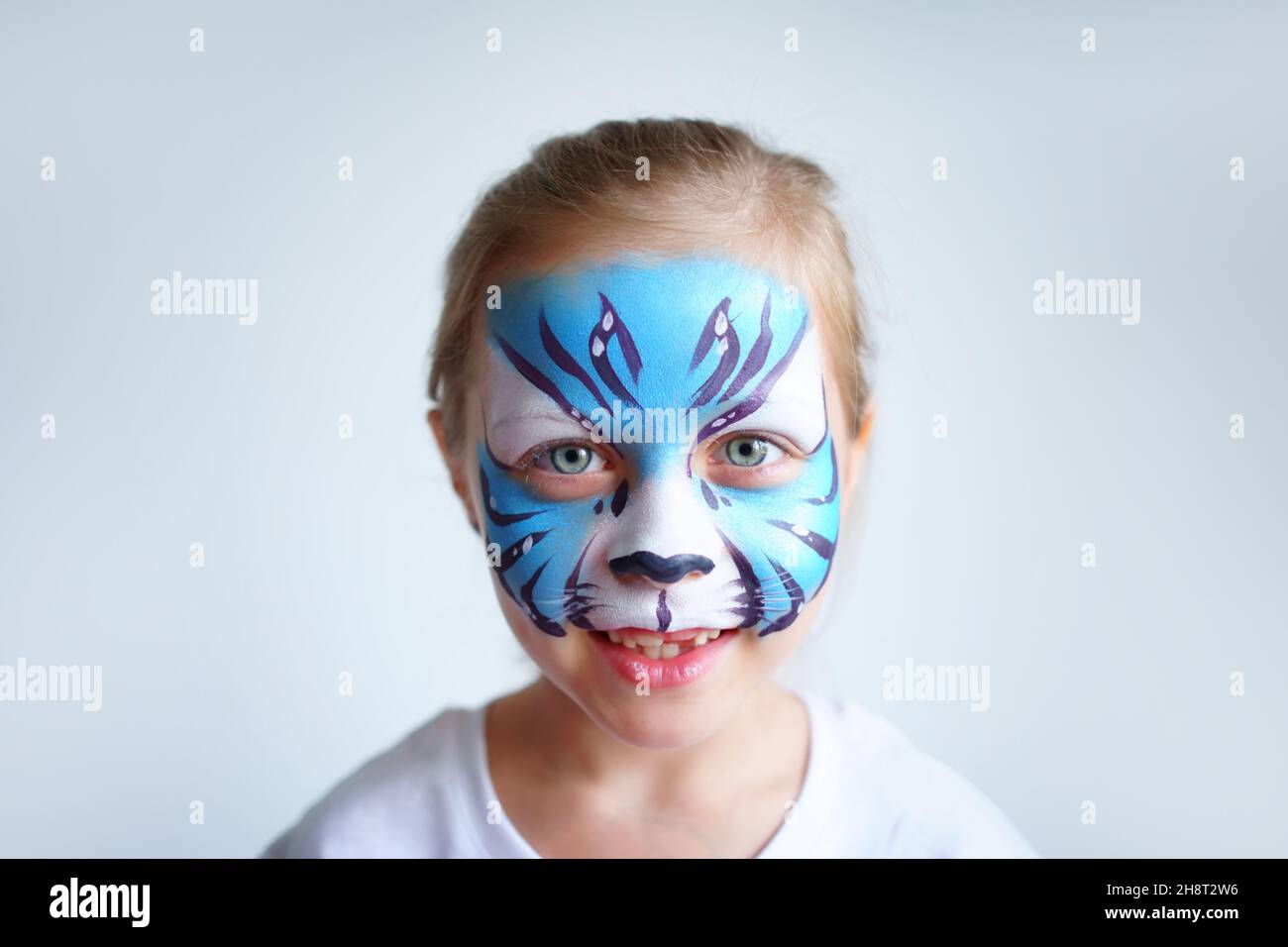 Mädchen Aqua Make-up in Form eines blauen Wassertiger Tierkreises auf weißem Hintergrund, Konzeptsymbol des neuen Jahres 2022, Lächeln Porträt Stockfoto
