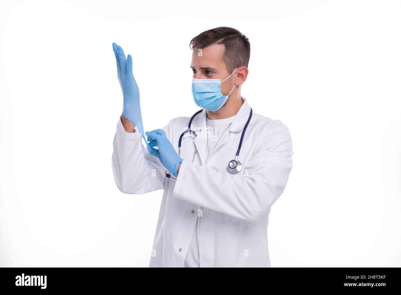 Arzt zieht Handschuhe an und trägt eine medizinische Maske isoliert. Mann  Arzt Schutz Maske Arbeitskleidung. Medizinisches Konzept Corona Virus  Stockfotografie - Alamy