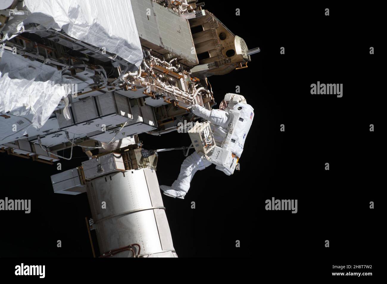 NASA-Spacewalker und Expedition 64-Flugingenieur Victor Glover arbeitet daran, am 27. Januar 2021 die Backbord-Traversenstruktur der Internationalen Raumstation für zukünftige Solar-Array-Upgrades vorzubereiten. Die NASA-Astronauten Mike Hopkins und Victor Glover installierten außerhalb des Columbus-Moduls der ESA (European Space Agency) eine Ka-Band-Antenne, die als COL-Ka bekannt ist, um eine unabhängige, bandbreitenintensive Kommunikationsverbindung zu europäischen Bodenstationen zu ermöglichen. Bartolomeo ist teilweise betriebsbereit und in einer sicheren Konfiguration nach dem Anschluss von vier von sechs Kabeln an die Wissenschaftsplattform, und die letzten beiden ca. Stockfoto
