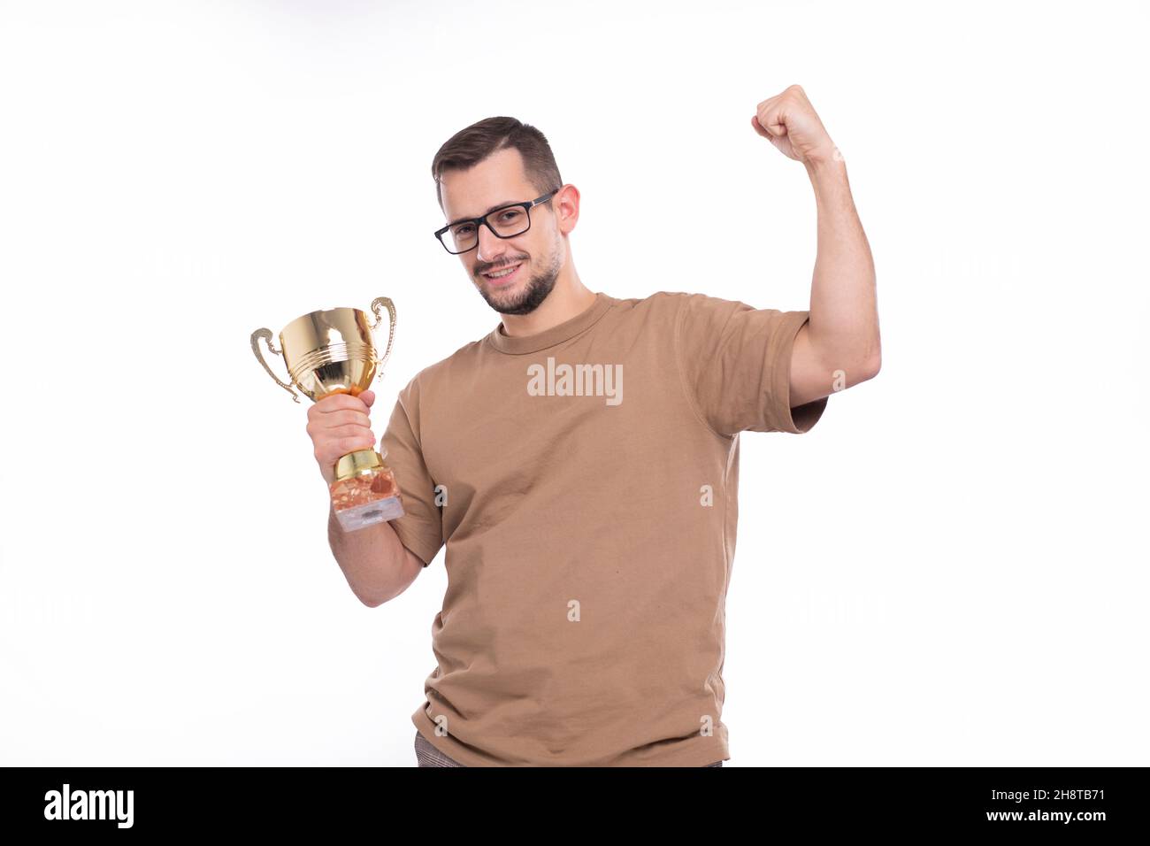 Mann sehr glücklich und aufgeregt, die Waffen heben, feiern einen Sieg oder Erfolg Holding Trophy. Sieger Zeichen. Eine isolierte mit Trophäe in den Händen Stockfoto
