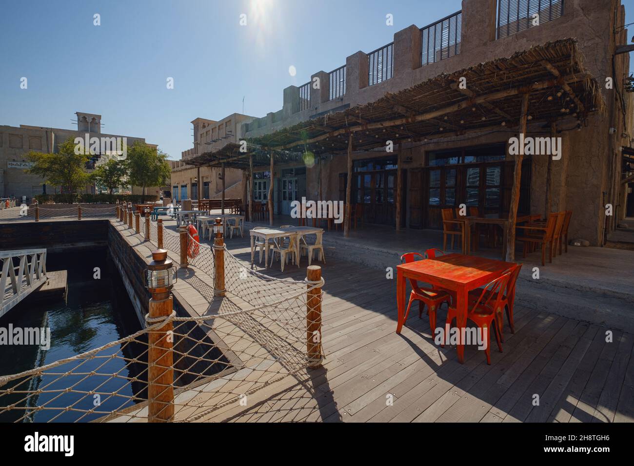 Dubai, VAE 17. Februar 2020: Alte Gebäude in Dubai und arabische Straße. Historisches Al Fahidi Viertel, Al Bastakiya. Heritage District in Vereinigte Arabische Emirate. Restaurant auf dem Pier Stockfoto