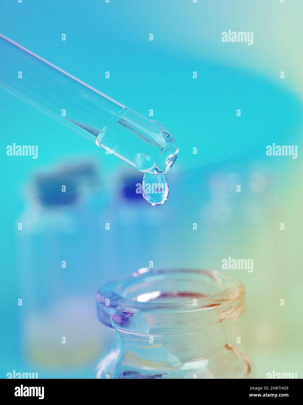 Tropfen Flüssigkeit aus einer Pipette in eine medizinische Flasche, Forschungskonzept, neue Medikamente und Wissenschaft, auf einem hellen rosa, blauen und violetten Hintergrund. Stockfoto