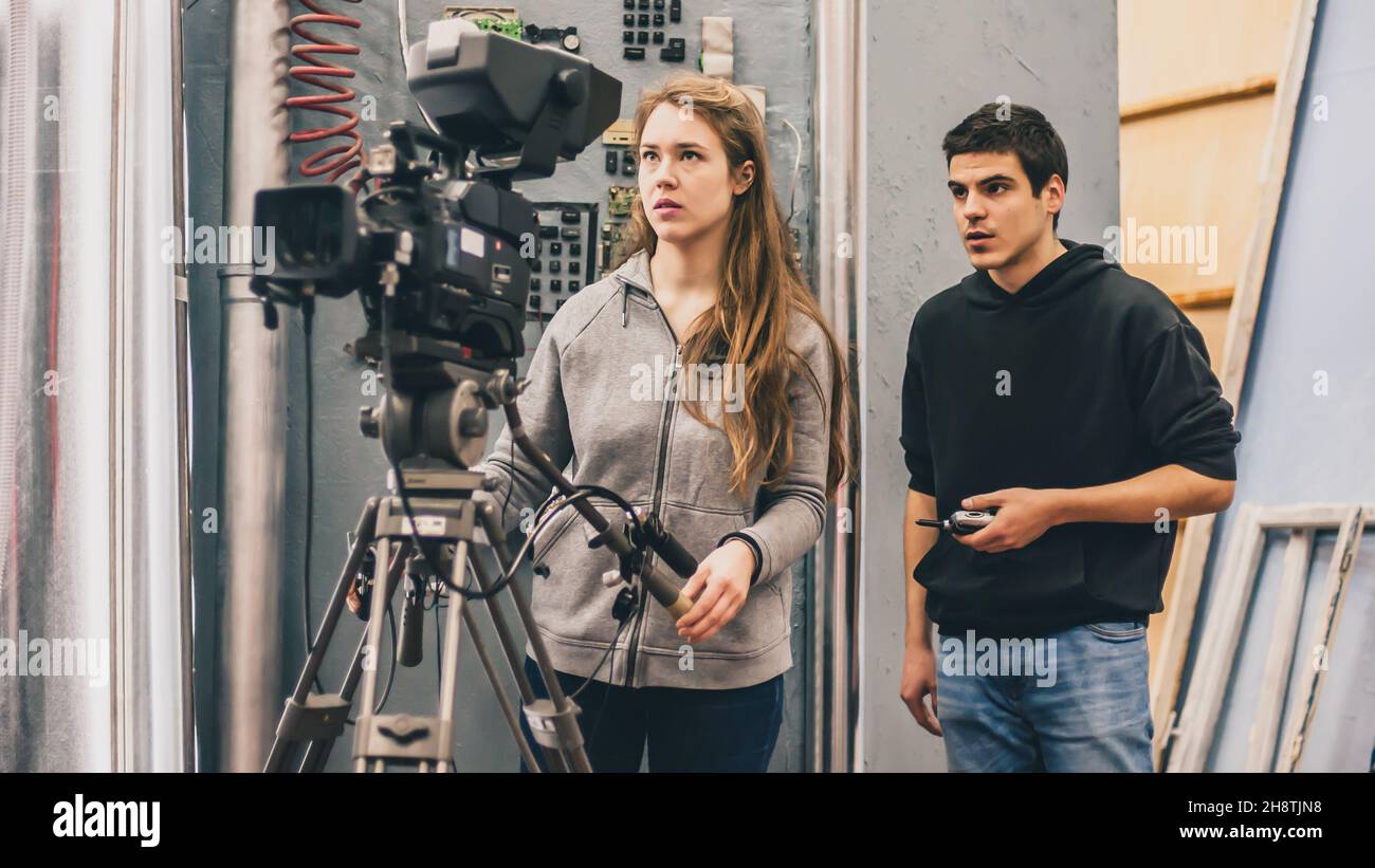 Hinter der Bühne. Kameramann und Assistent, der die Filmszene mit der Kamera im Filmstudio dreht Stockfoto