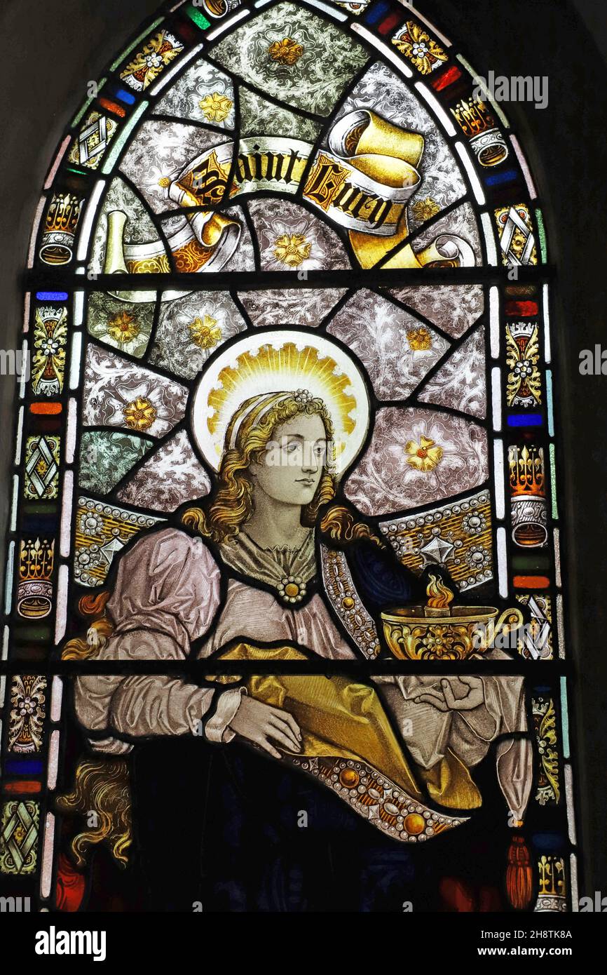 Ein Buntglasfenster aus dem Jahr 1896 von Percy Bacon & Brothers mit der Darstellung der Heiligen Lucy, der St. Mary Magdalene Church, Ripley, Surrey Stockfoto