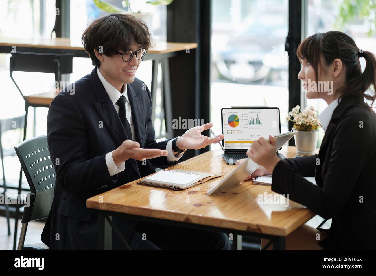 Geschäftsleute diskutieren die Diagramme und Grafiken, die die Ergebnisse ihrer erfolgreichen Teamarbeit zeigen. Stockfoto
