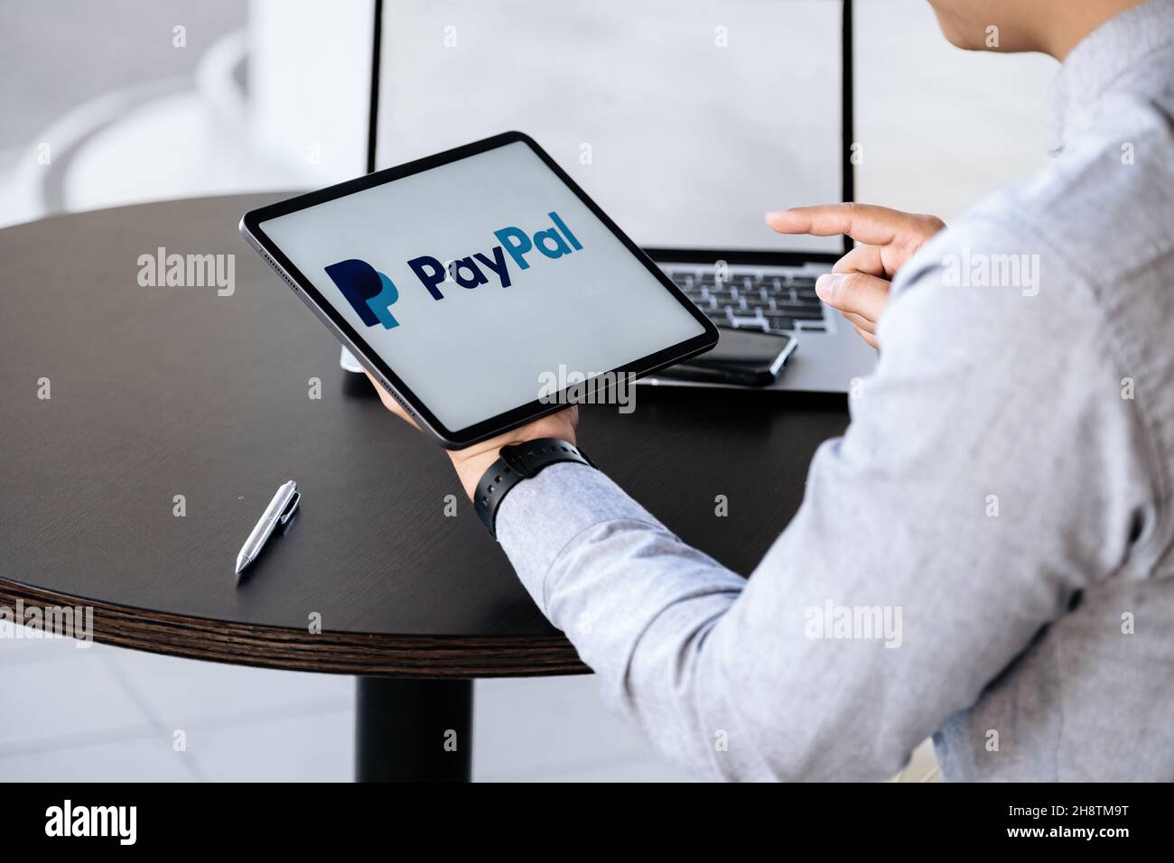 CHIANG MAI, THAILAND - NOV 28, 2021 : Mann Hände halten ipad mit PayPal-Apps auf dem Bildschirm. PayPal ist ein elektronisches Online-Zahlungssystem. Stockfoto